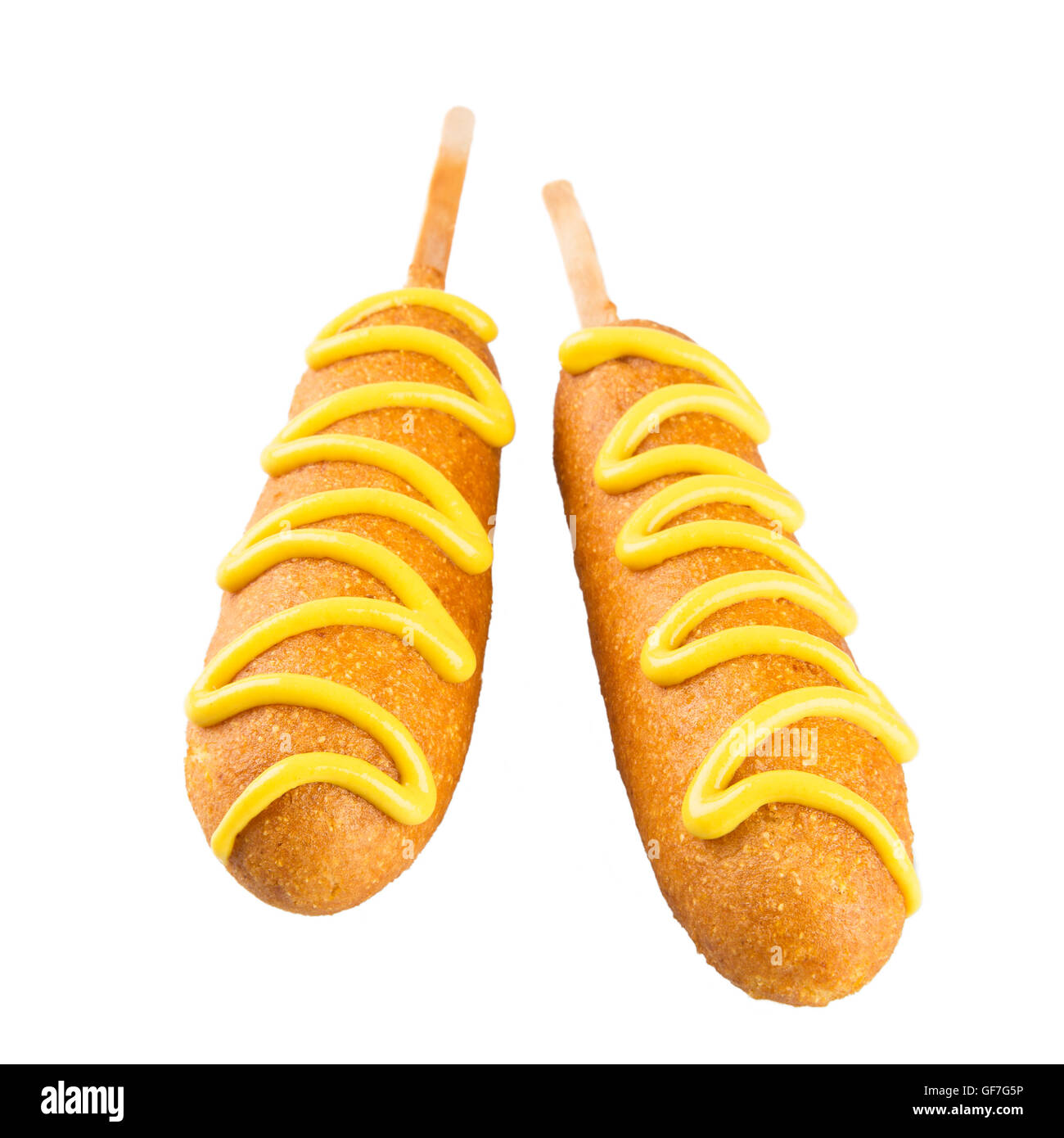 Zwei Corndogs isoliert auf einem weißen Hintergrund, die gekrönt mit Senf Stockfoto