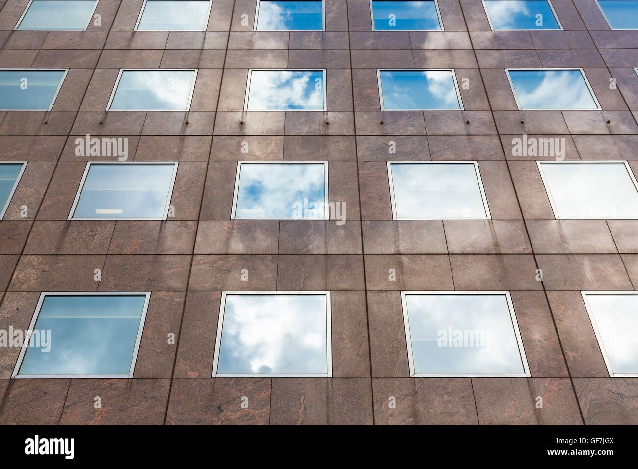 Wolken-Reflexionen auf einem Gebäude mit quadratischen Fenstern in London Stockfoto