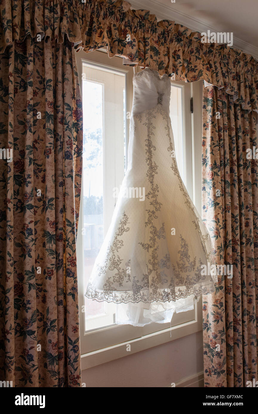 Brautkleid hängen im Fensterlicht. Stockfoto