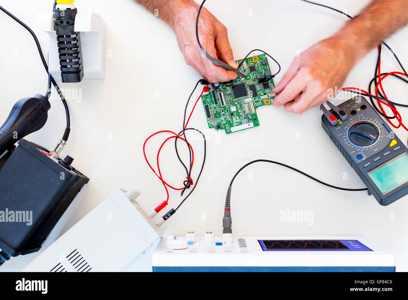 Entwicklung von elektronischen Geräten im modernen Elektronik-Labor auf einem Tisch, Mikroprozessor-Oszilloskop und multimeter Stockfoto