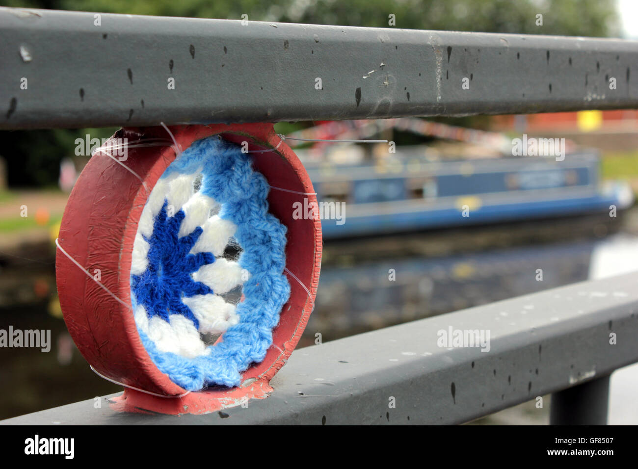 Ein häkeln Kanal Rad und Girlanden angebracht um eine Fußgängerbrücke über den Leeds und Liverpool Canal in Blackburn, Lancashire. Stockfoto