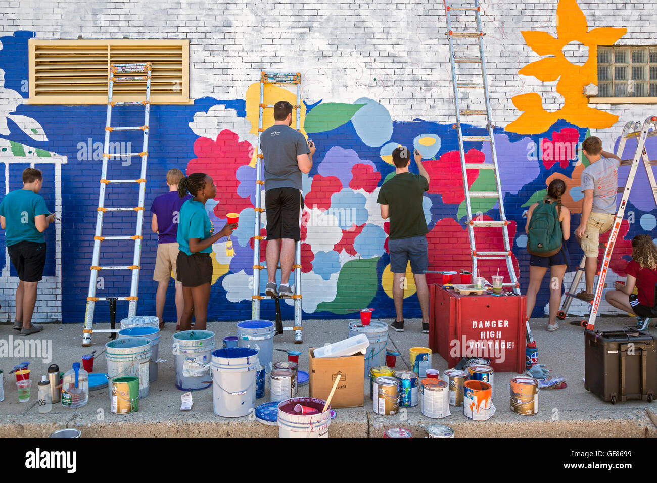 Detroit, Michigan - Junge Freiwillige Farbe auf die Wand einer Münzwaschmaschine im Morningside Nachbarschaft. Stockfoto