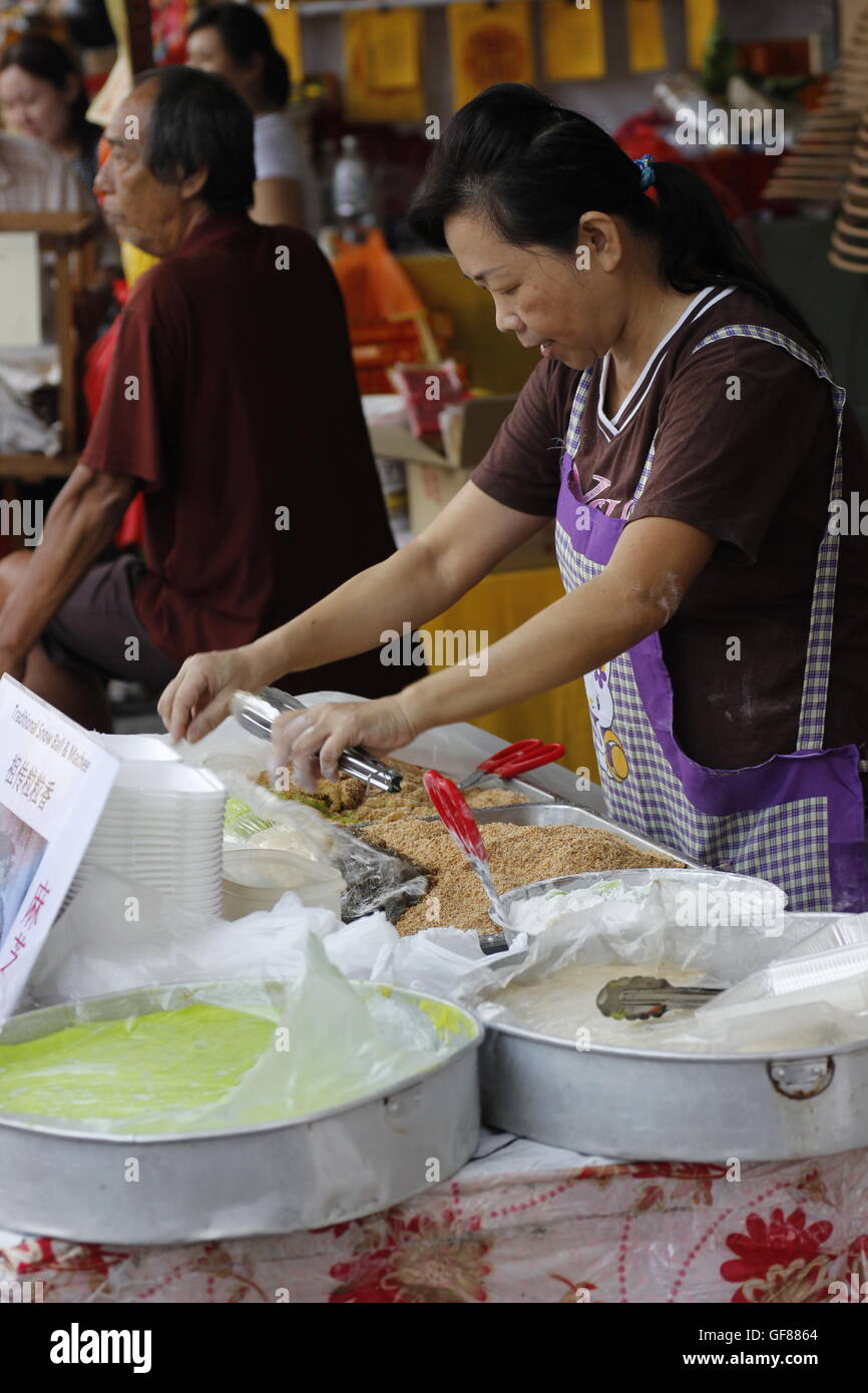 Frau am Stand machen Muah Chee (Glutinous Reis Snacks mit Erdnuss & Zucker) Stockfoto