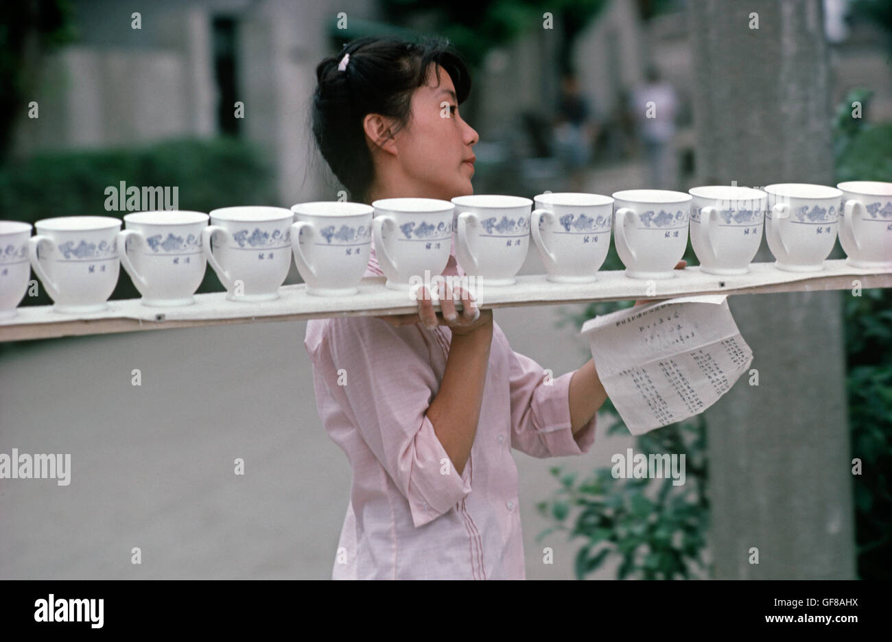 Chinesische Frau Arbeiter mit Tablett Porzellan Tassen, Shaoxing Porzellanfabrik, Shaoxing, China Stockfoto