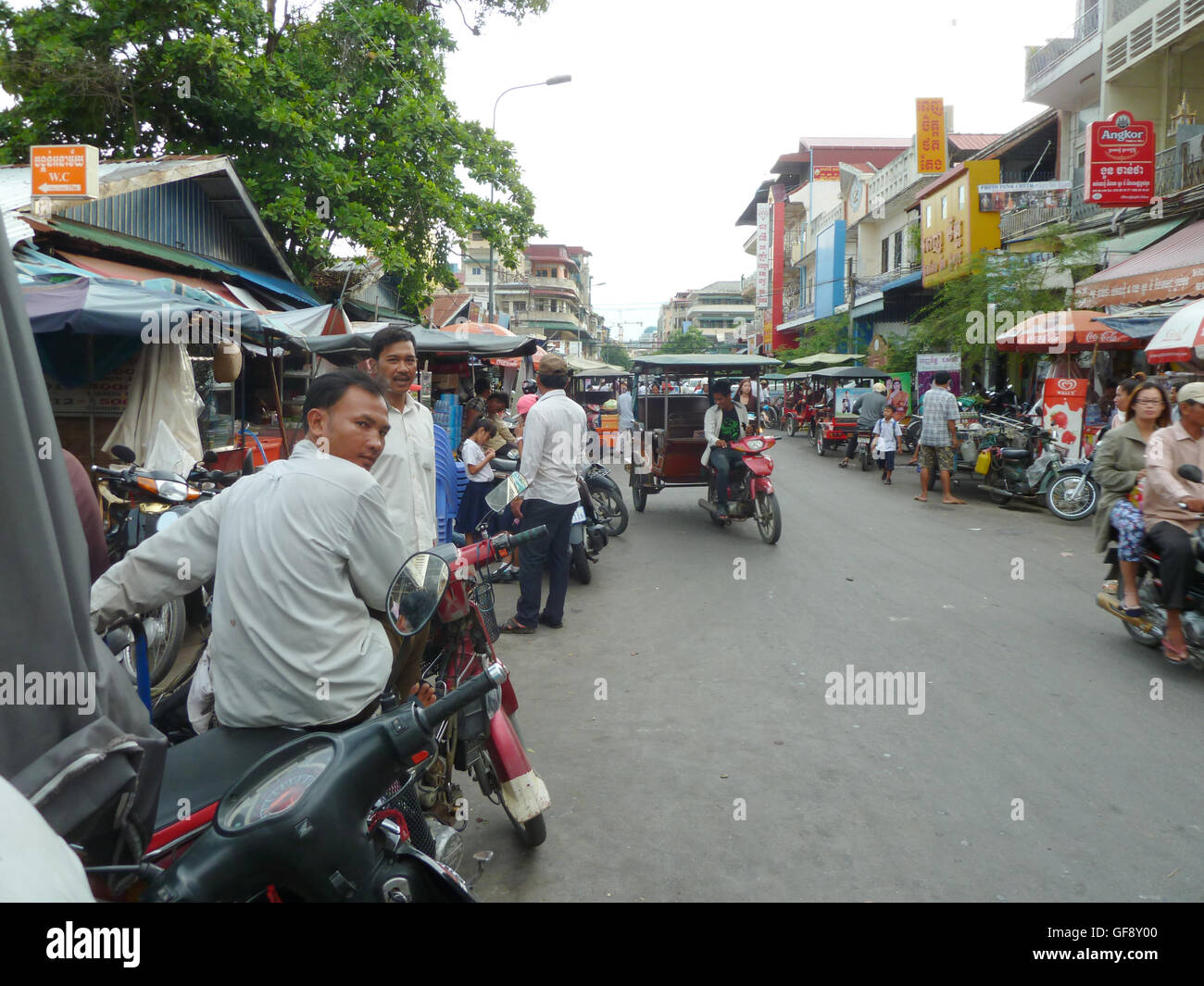 Straßenszene in Phnom Penh mit Menschen auf dem Weg zur Arbeit im Auto und Motorräder. Sehr lebhaften und pulsierenden kambodschanischen Stadt. Stockfoto