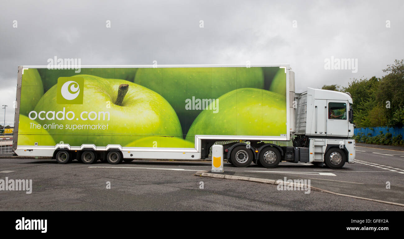 Ocado Apple Van livery & Morrisons Supermarkt Lebensmittel Lieferservice Food Store Fahrzeuge; online Fuhrpark liefern, Lebensmittel und Dinge des tägl. Bedarfs in Liverpool, Merseyside, UK Stockfoto