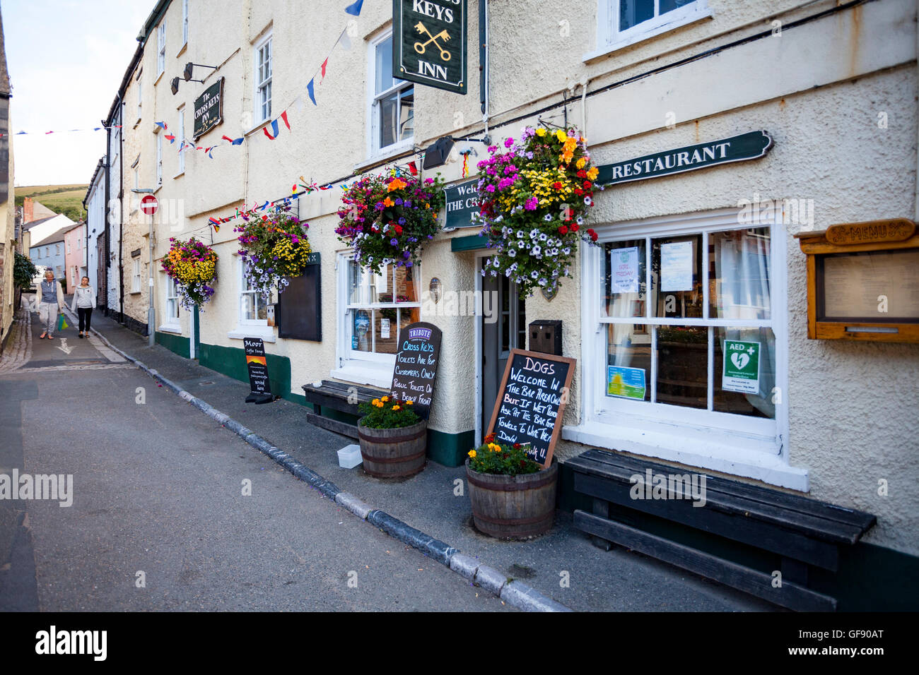 Cross Keys Inn, Cawsand, Cornwall, England UK am frühen Morgen im Sommer mit voller Blumen Blumenampeln auf dem display Stockfoto