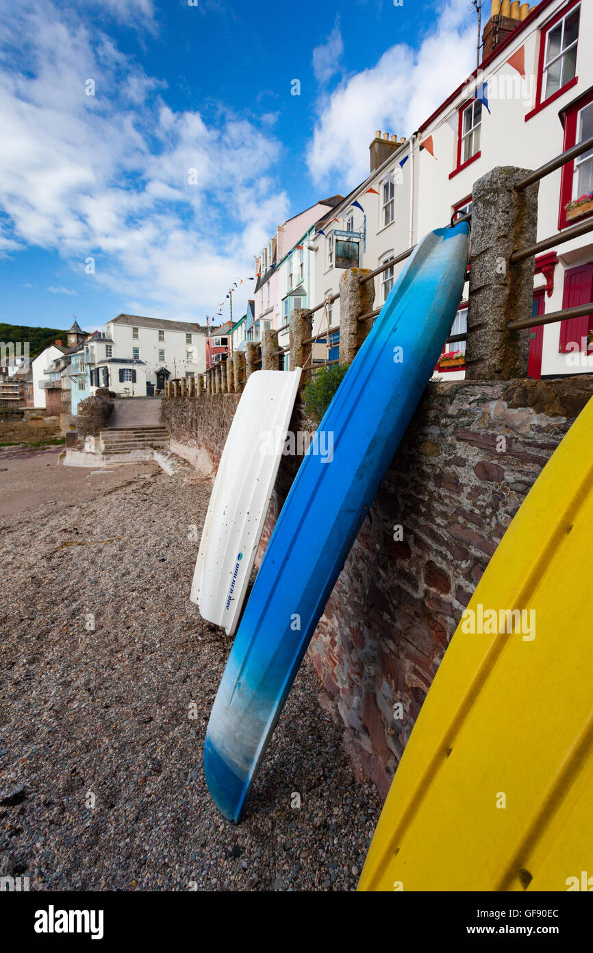 Boote und Kanus lehnte sich gegen die Küsten Wand bei Kingsand, Cornwall, England, UK Stockfoto