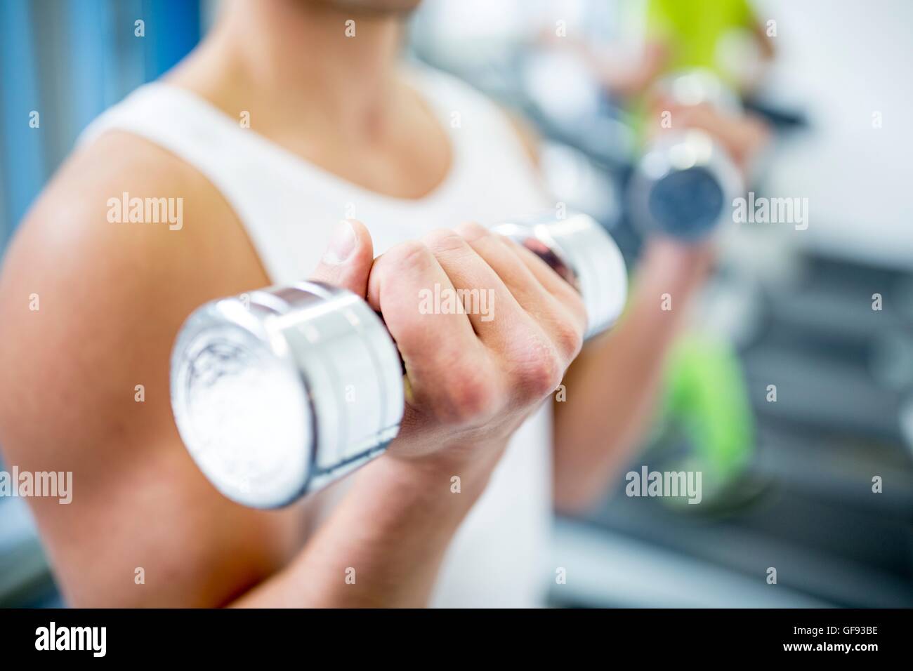 EIGENTUM FREIGEGEBEN. -MODELL VERÖFFENTLICHT. Junger Mann mit Hanteln beim trainieren, close-up. Stockfoto