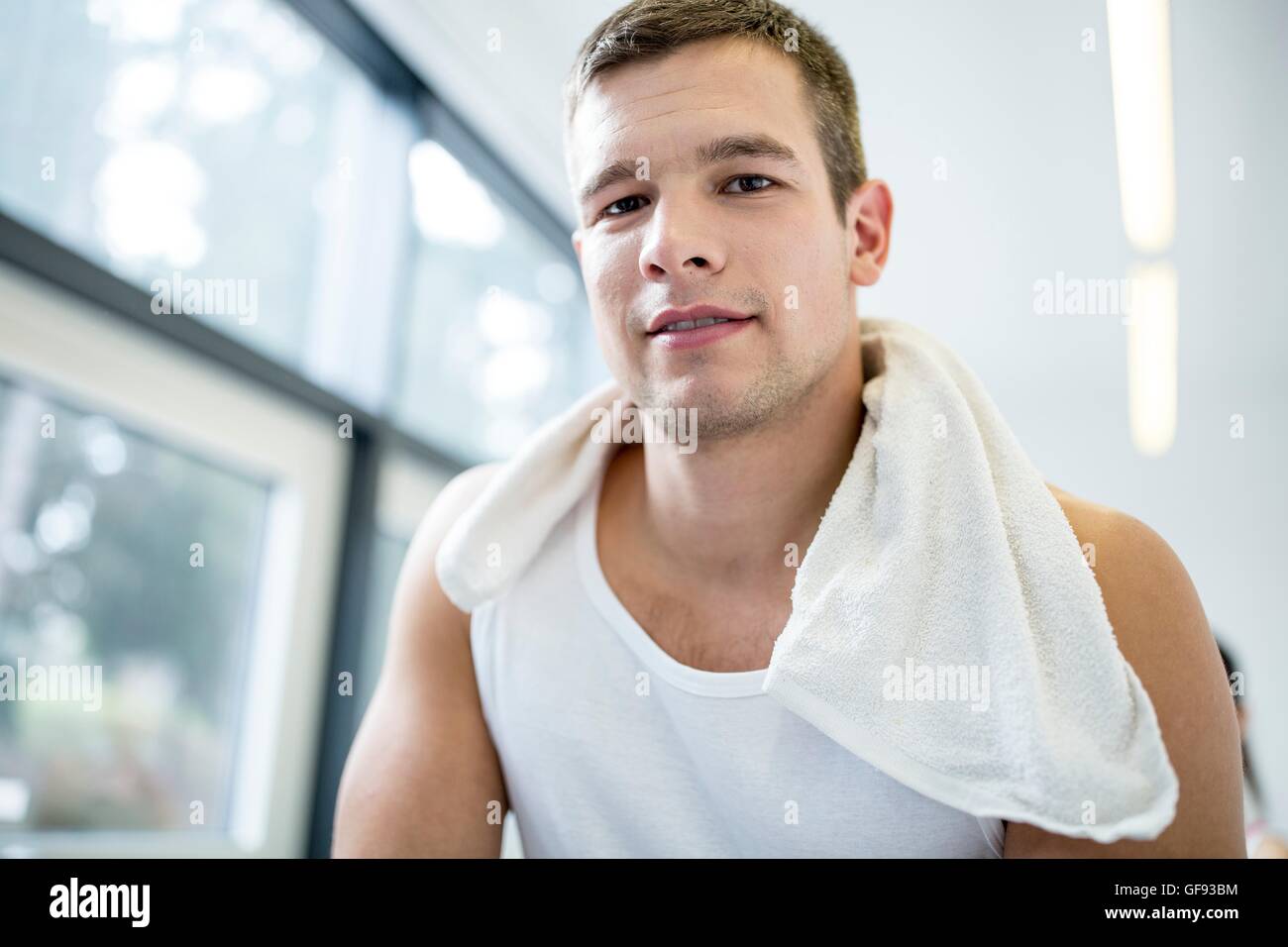 EIGENTUM FREIGEGEBEN. -MODELL VERÖFFENTLICHT. Porträt des jungen Mannes mit Serviette um Hals im Fitness-Studio, close-up. Stockfoto