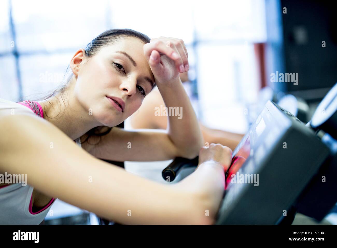 EIGENTUM FREIGEGEBEN. -MODELL VERÖFFENTLICHT. Close-up jungen Frau ruht auf Heimtrainer im Fitness-Studio, Porträt. Stockfoto