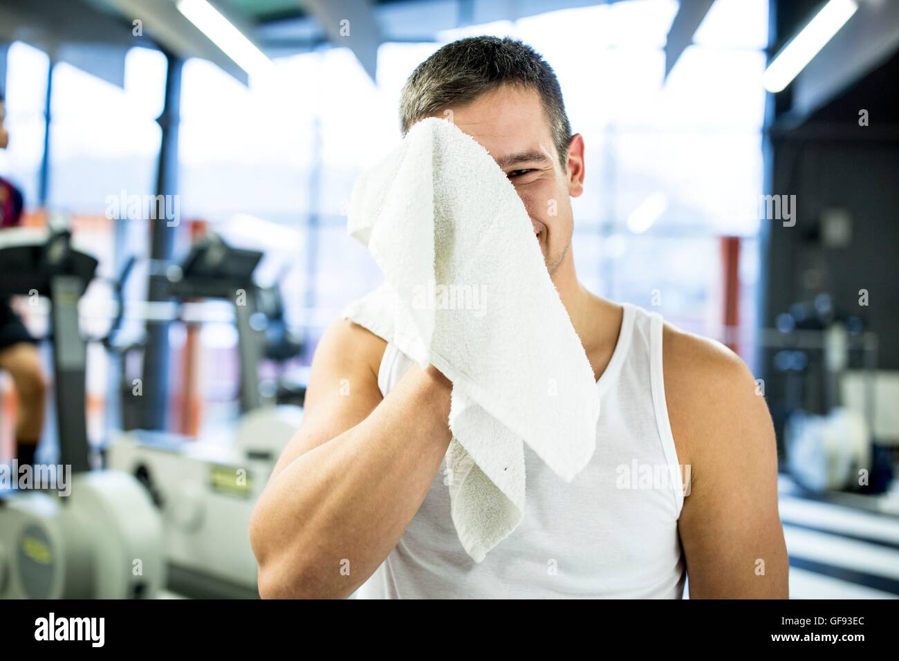 EIGENTUM FREIGEGEBEN. -MODELL VERÖFFENTLICHT. Porträt junger Mann wischte sich sein Schweiß mit Handtuch nach dem Training im Fitness-Studio. Stockfoto