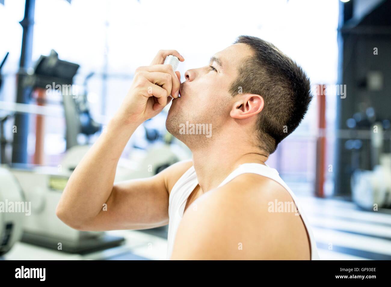 EIGENTUM FREIGEGEBEN. -MODELL VERÖFFENTLICHT. Junger Mann mit Inhalator im Fitness-Studio. Stockfoto
