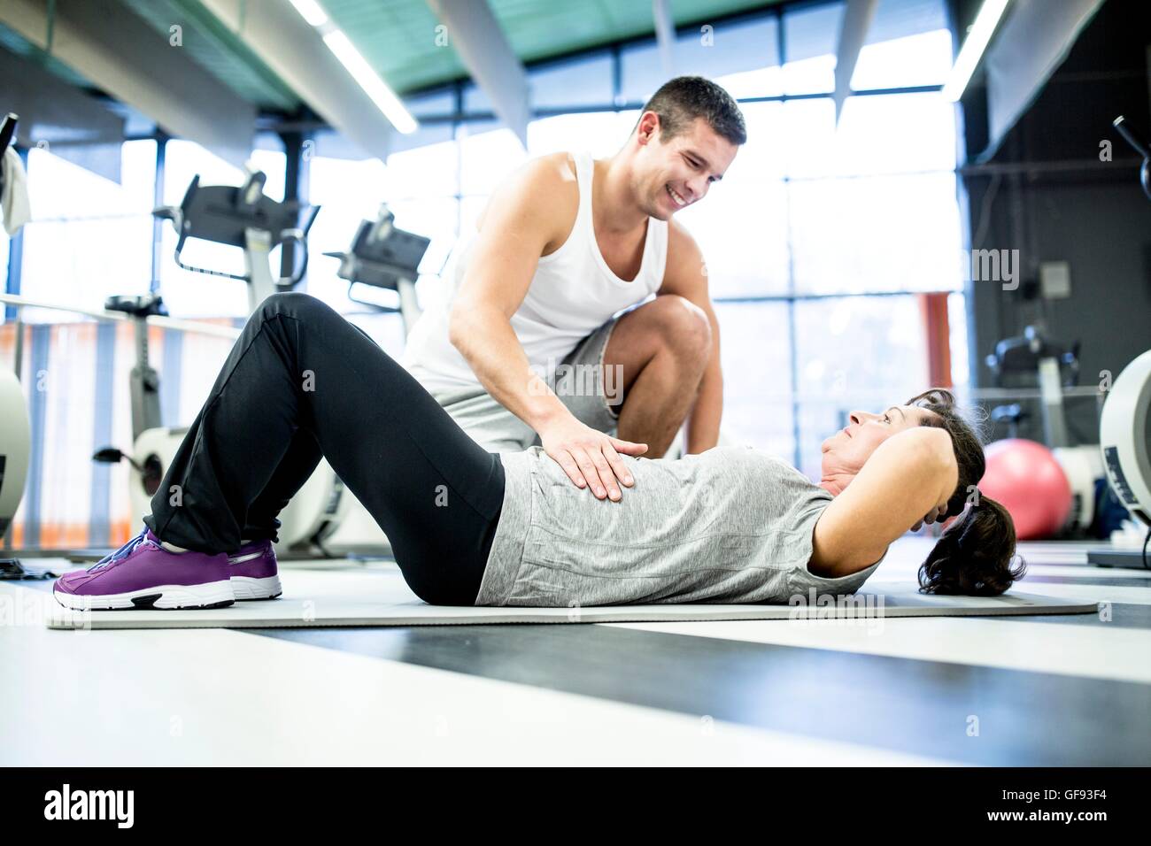 EIGENTUM FREIGEGEBEN. -MODELL VERÖFFENTLICHT. Junger Mann Tauchlehrerausbildung mit senior Frau im Fitness-Studio. Stockfoto