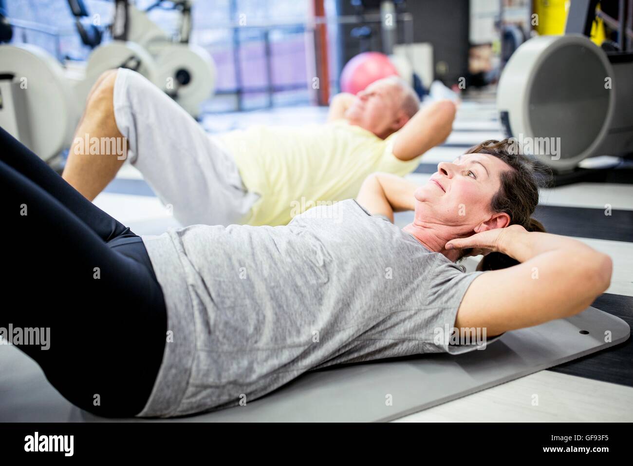 EIGENTUM FREIGEGEBEN. -MODELL VERÖFFENTLICHT. Zwei ältere Leute im Fitnessstudio trainieren. Stockfoto
