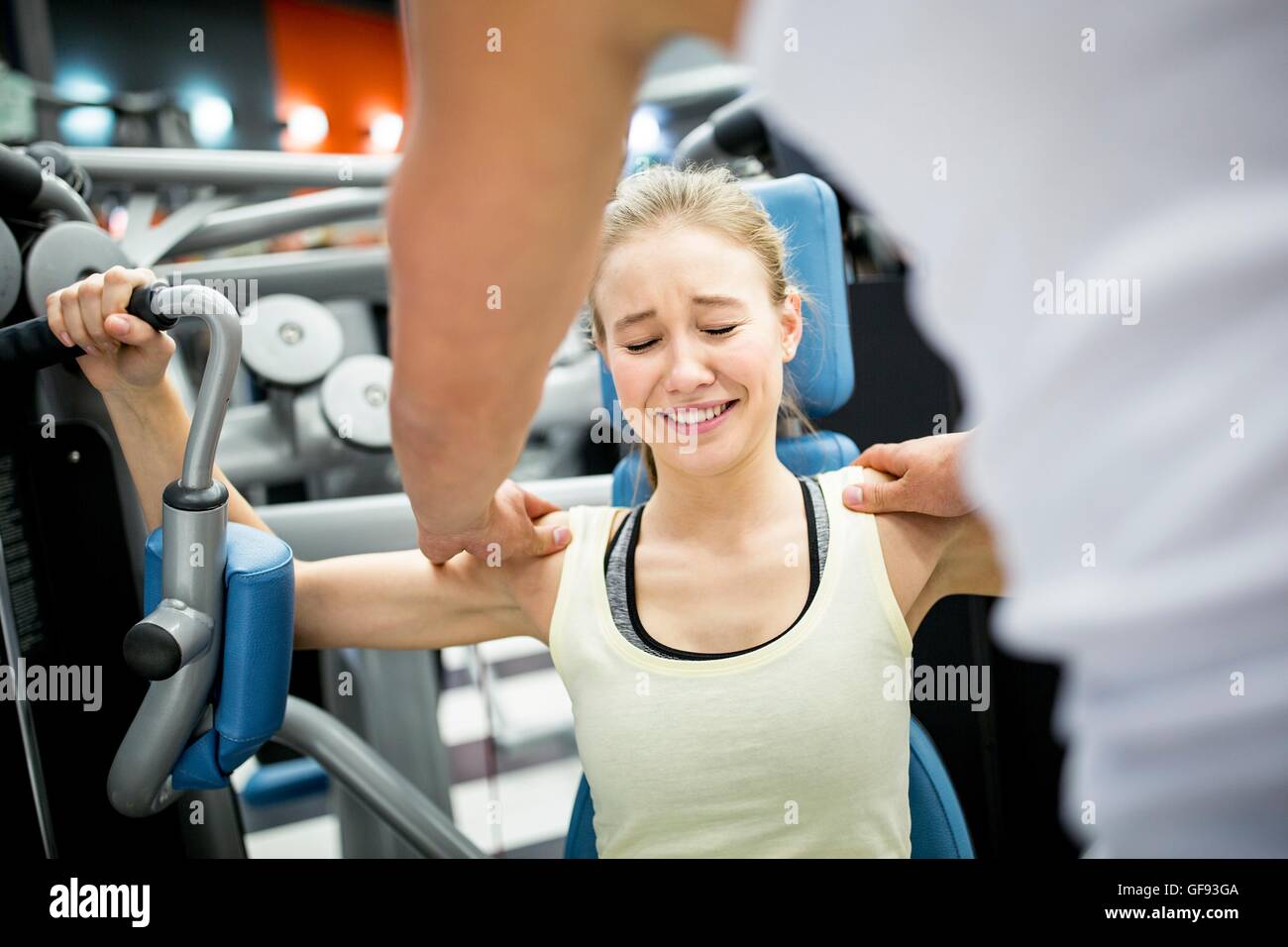 EIGENTUM FREIGEGEBEN. -MODELL VERÖFFENTLICHT. Junge Frau in Schmerzen beim trainieren im Fitnessraum. Stockfoto