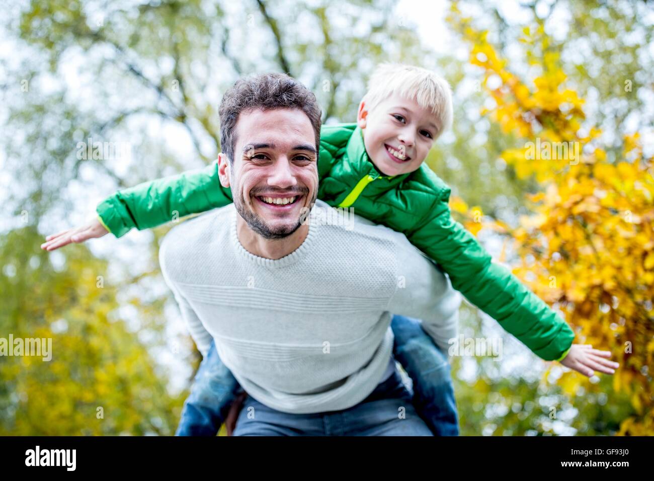 -MODELL VERÖFFENTLICHT. Vater mit Sohn Huckepack im Herbst, Lächeln, Porträt. Stockfoto
