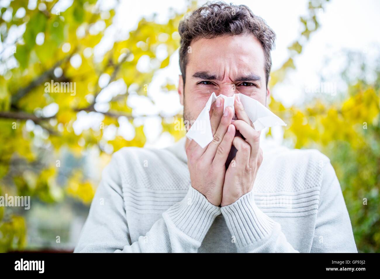 -MODELL VERÖFFENTLICHT. Junger Mann Niesen, Porträt, Nahaufnahme. Stockfoto