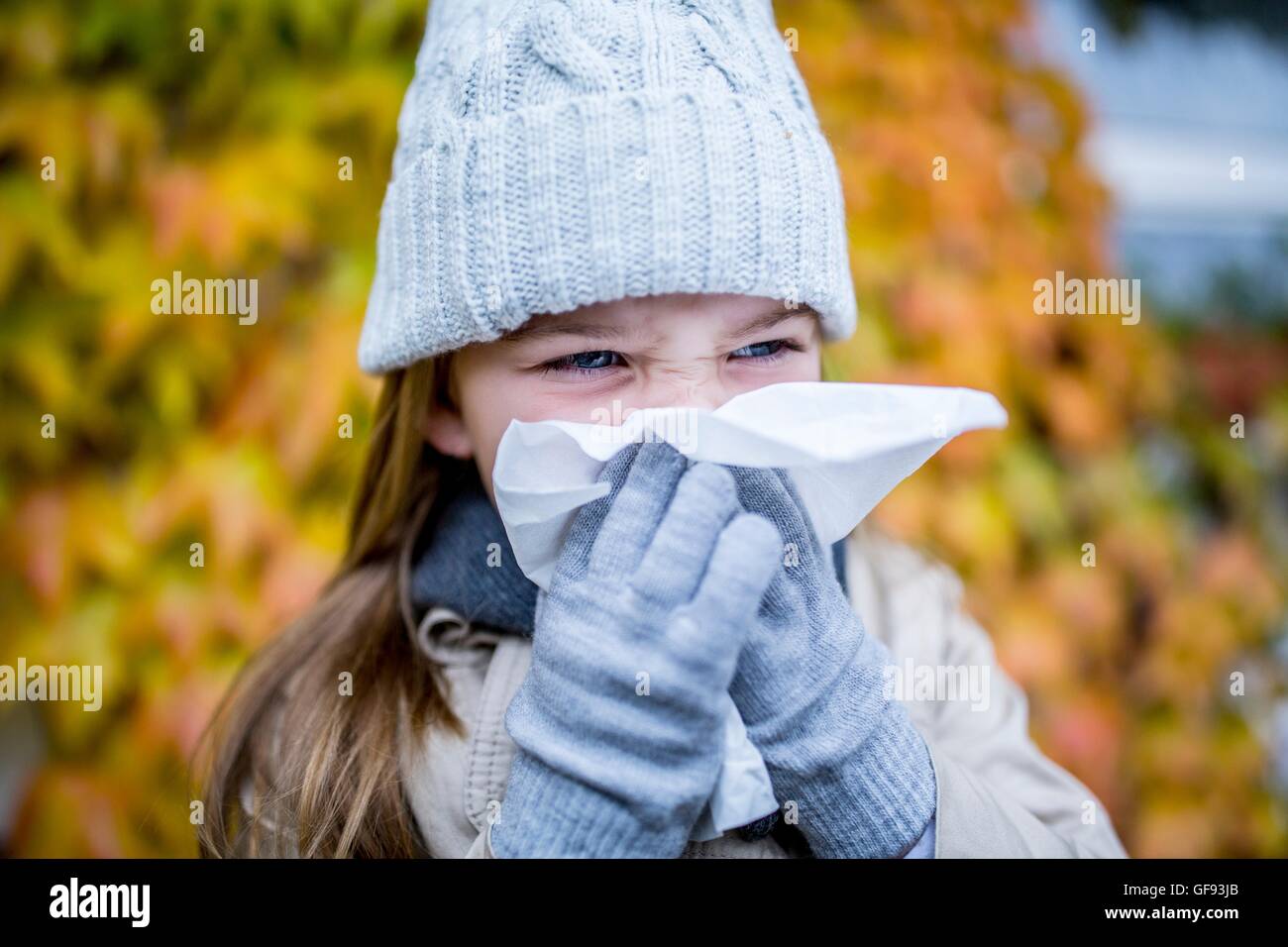 -MODELL VERÖFFENTLICHT. Junges Mädchen Niesen, close-up. Stockfoto