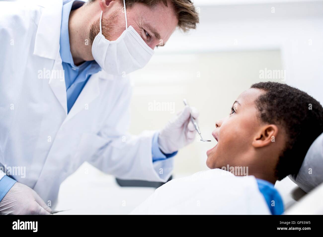 -MODELL VERÖFFENTLICHT. Arzt Untersuchung junge Zähne in Klinik. Stockfoto