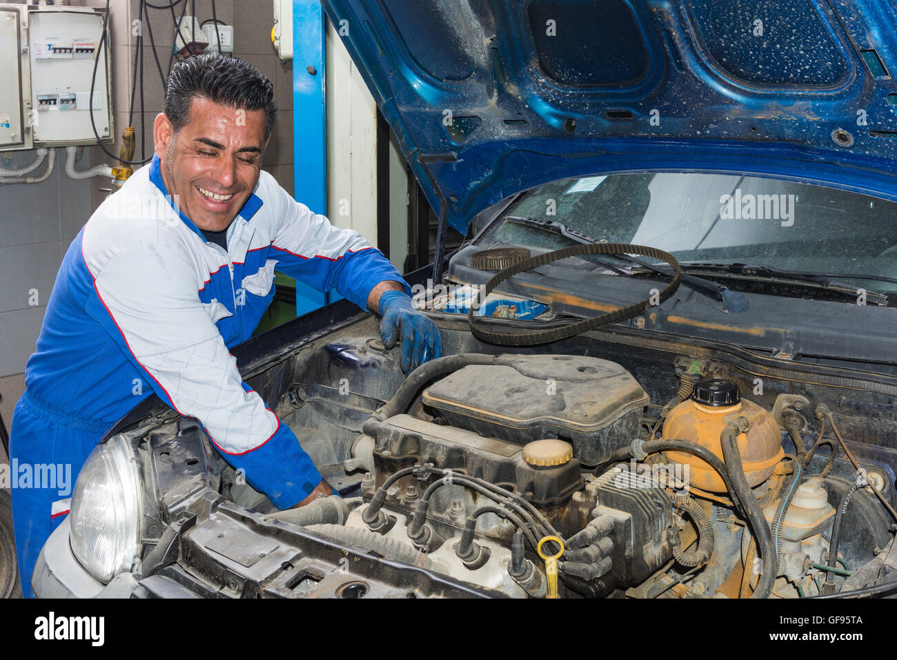 Kfz-Mechaniker Befestigung eines Motors in seiner Garage. Eine Nahaufnahme von einem erfahrenen Mechaniker Wartung eines Autos in der Garage. Ein Mechaniker an Stockfoto