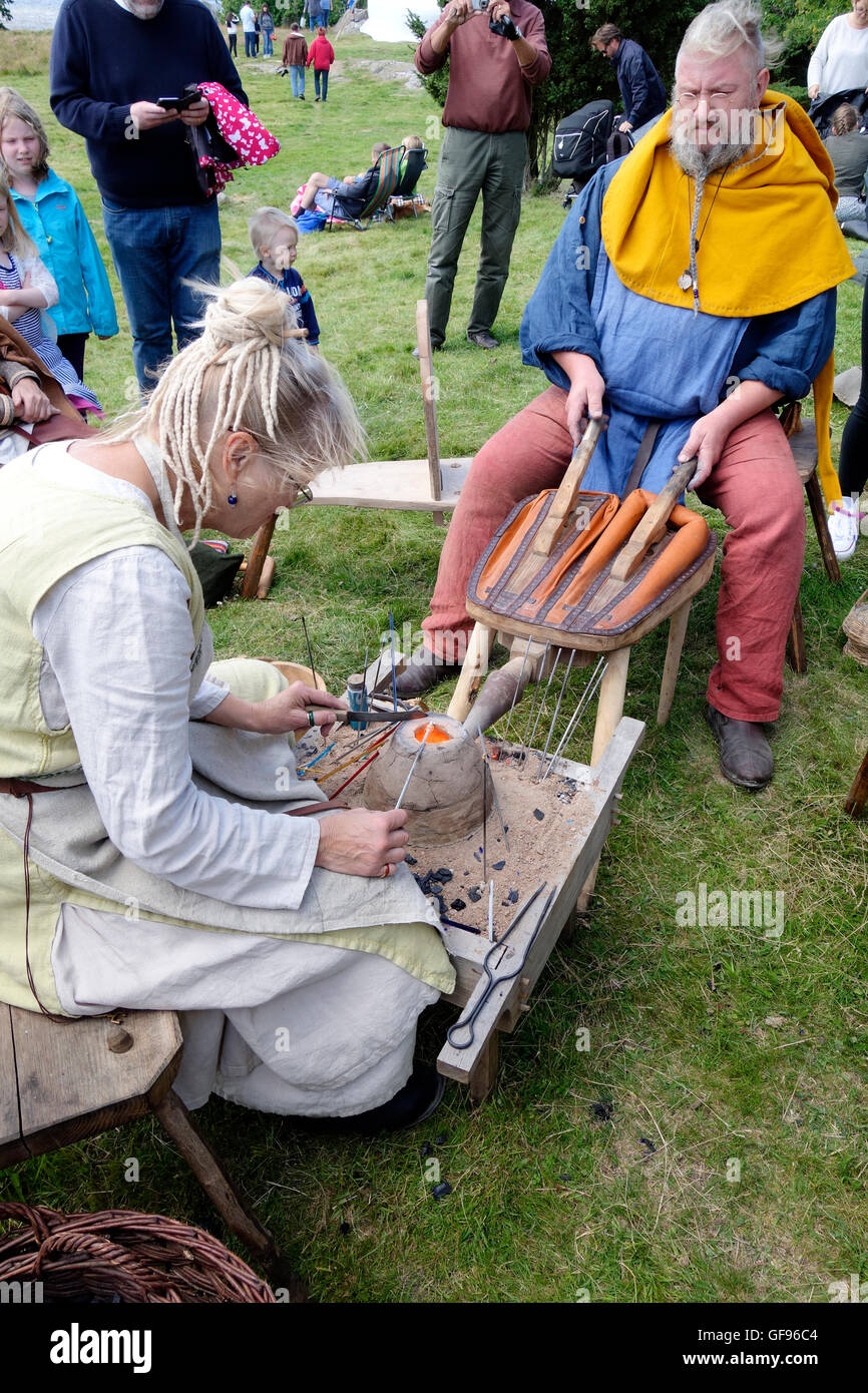 Älteres Ehepaar zeigt die frühen mittelalterlichen Glasperlen-Herstellung mit Hilfe von kleinen tragbaren Ton Ofen, Kungsbacka, Schweden Stockfoto
