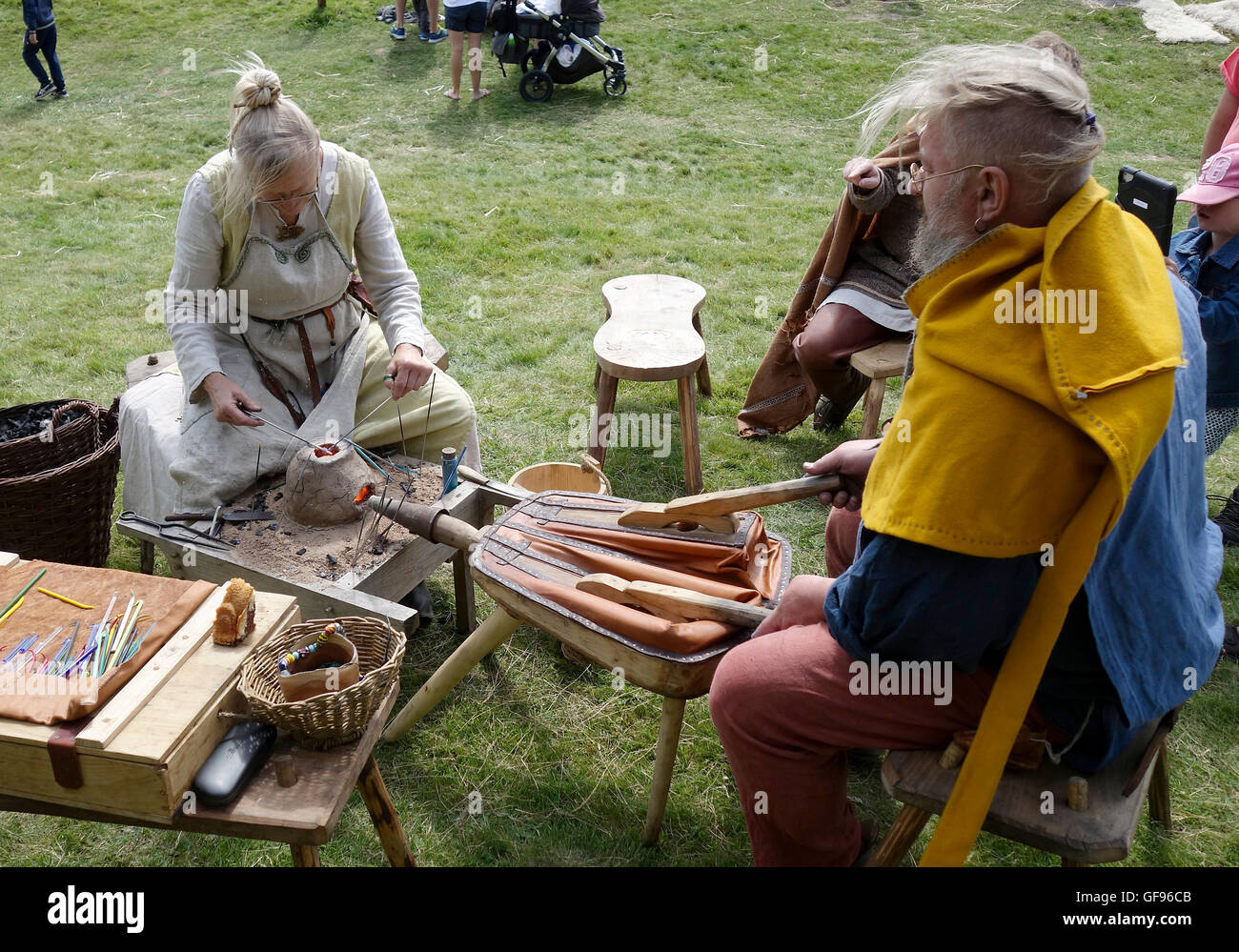 Älteres Ehepaar zeigt die frühen mittelalterlichen Glasperlen-Herstellung mit Hilfe von kleinen tragbaren Ton Ofen, Kungsbacka, Schweden Stockfoto