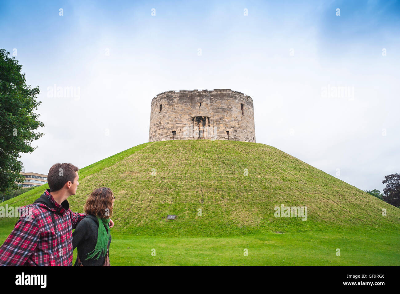 Clifford's Tower York UK, Blick auf Touristen, die am Norman Keep, auch bekannt als Clifford's Tower, im Zentrum der Stadt York, England, vorbeilaufen. Stockfoto