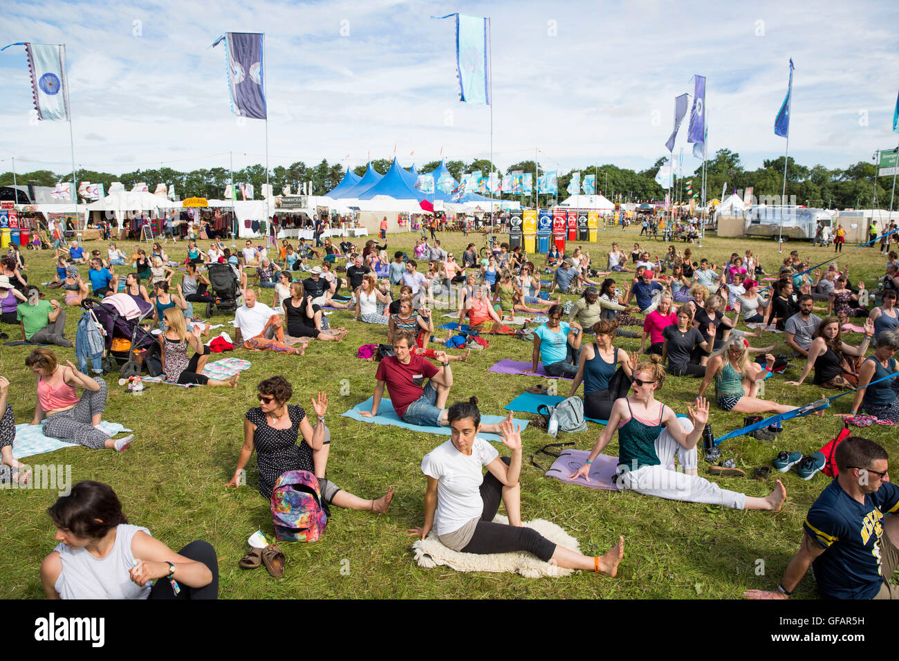 Charlton Park, UK. 30. Juli 2016. Hunderte von Menschen beteiligen sich an einer Yoga-Sitzung morgen Gruppe an einem sonnigen WOMAD Festival, 30. Juli 2016. Bildnachweis: Adam Gasson/Alamy Live-Nachrichten Stockfoto