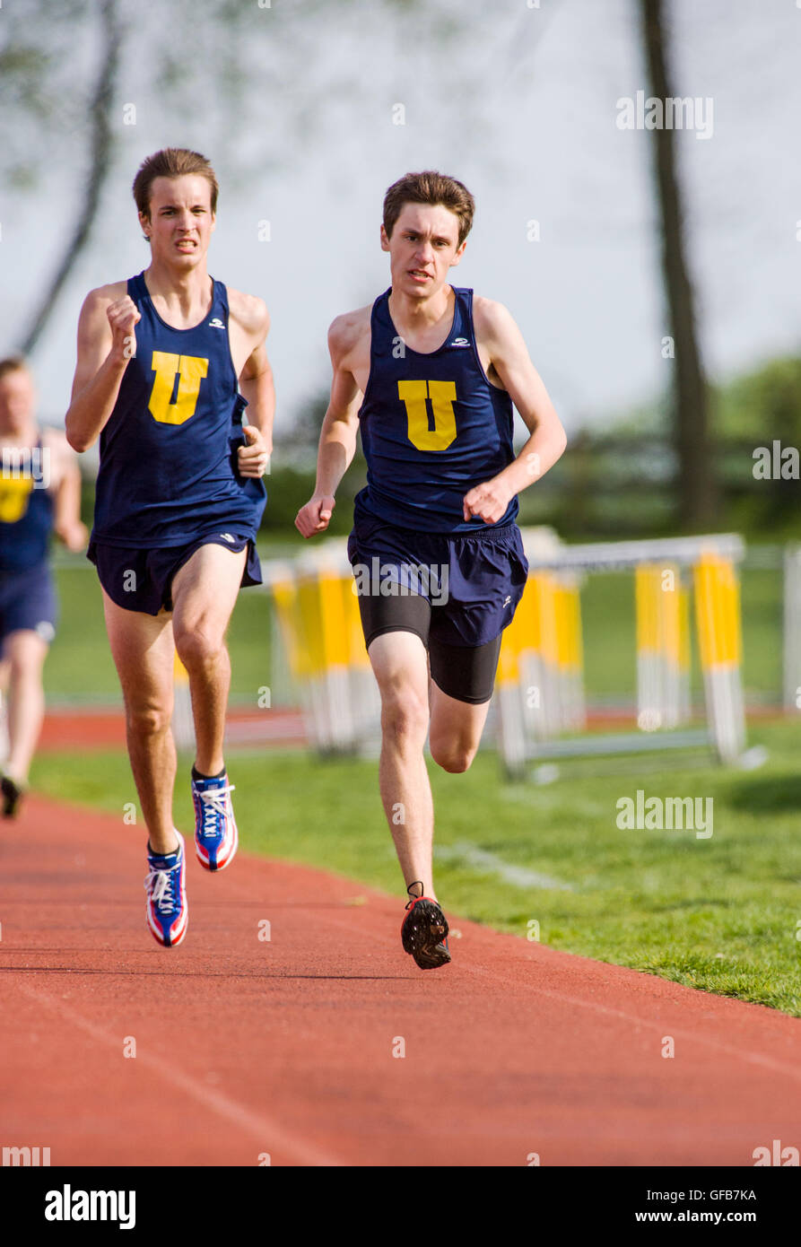 Läufer auf der Strecke während eines High-School-Tracks konkurrieren & Feld gerecht zu werden. Stockfoto