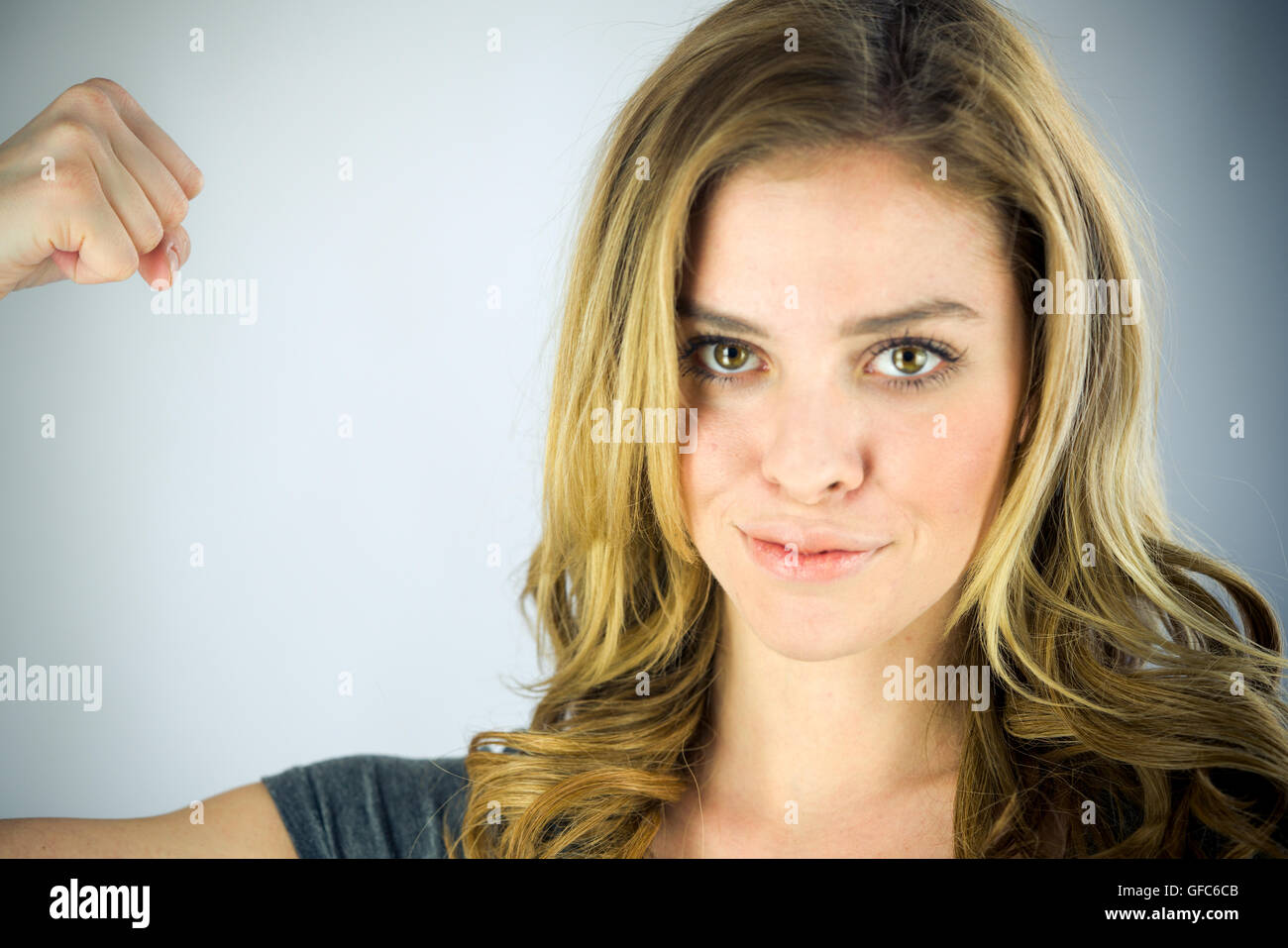 weibliches Model attraktive Frau zeigt Stärke mit Arm-curl Stockfoto