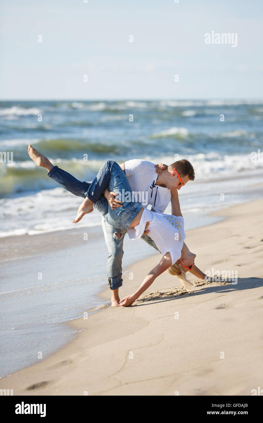 Fröhliches paar machen akrobatischen Tanz am Strand, Sommerzeit Stockfoto