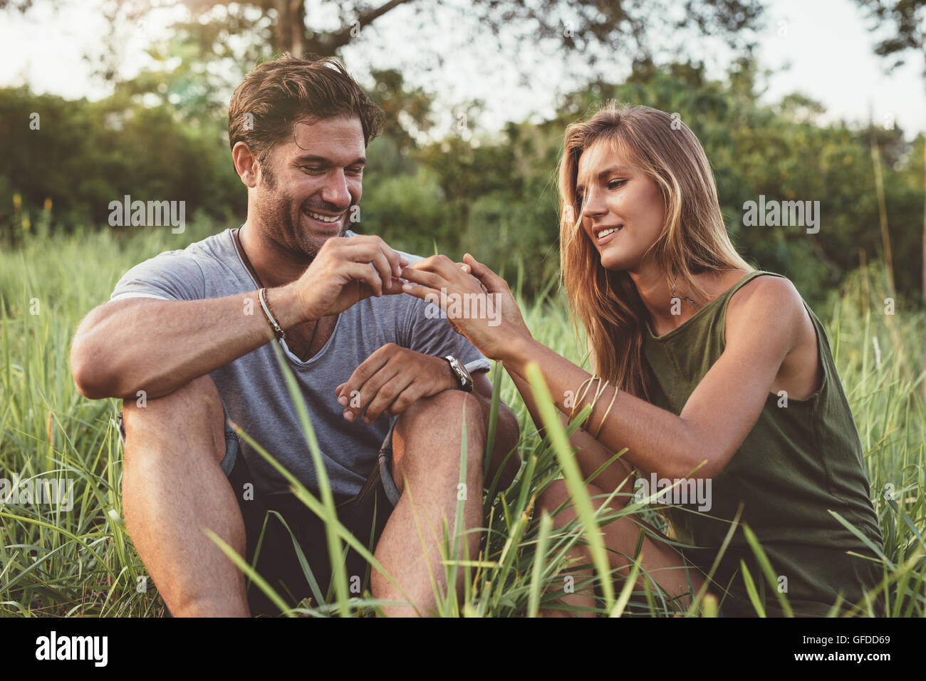 Im Freien Schuss des Mannes Ring am Finger der jungen Frau zu platzieren. Mann schlägt vor, Freundin. Stockfoto