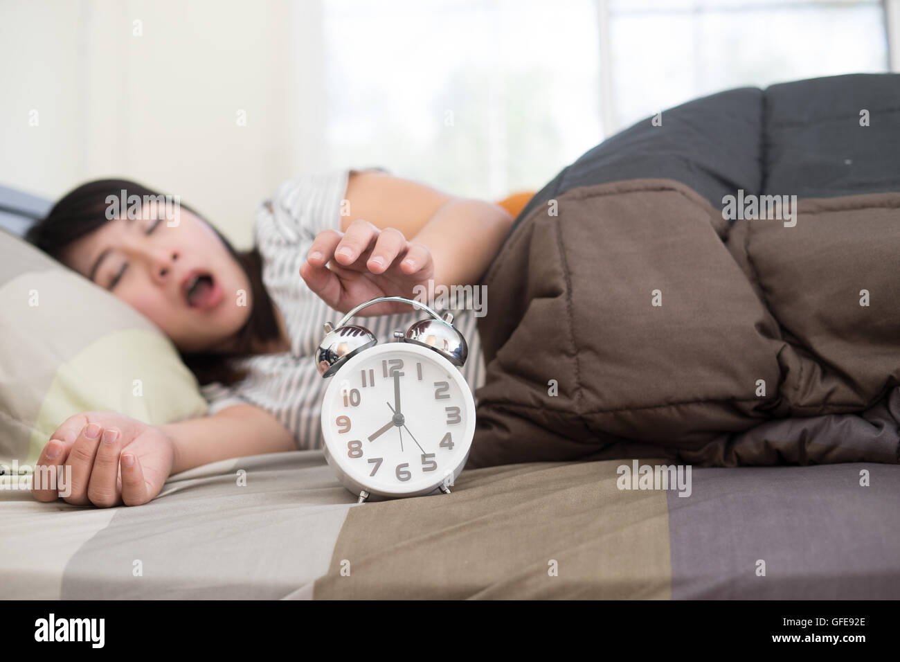 Junge Frau, die immer über aufwachen zu früh, flache Schärfentiefe, Fokus auf Vordergrund betont Stockfoto