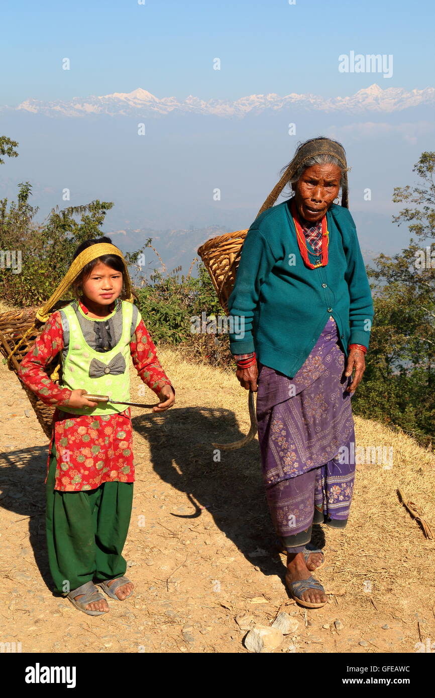 Eine alte Frau und ein kleines Mädchen mit einem Korb auf ihren Rücken, Landschaft, Dhulikhel, Nepal, Himalaya-Gebirge im Hintergrund Stockfoto