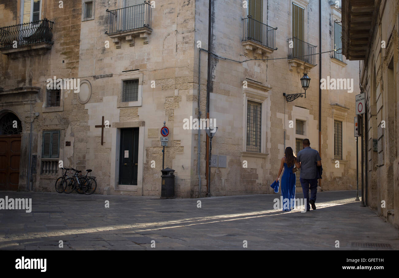 Zwei Menschen gehn durch eine Seitenstraße im historischen Bezirk von Lecce, Apulien, Italien Stockfoto