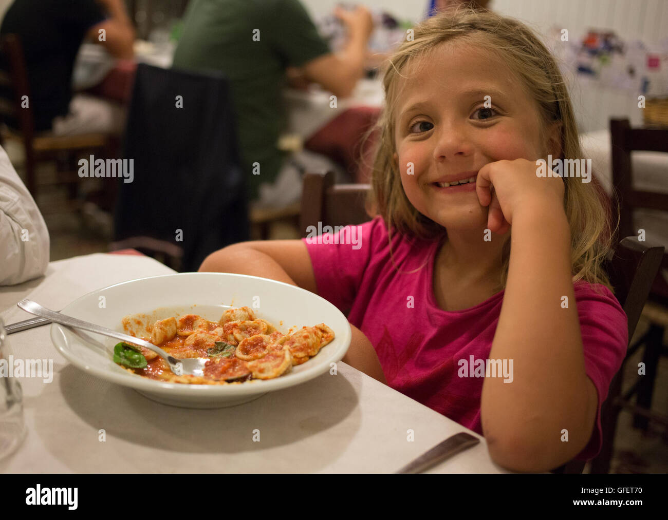 Ein junges Mädchen sitzt mit einem Teller Pasta Trattoria Cucina Casareccia Le Zie Restaurant in Lecce, Apulien, Italien 29. Juli 2016 Stockfoto