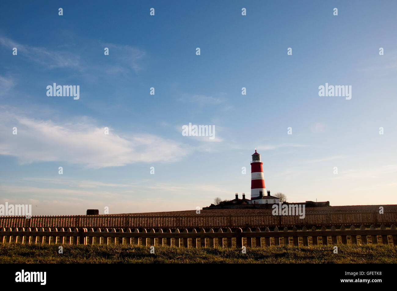 Happisburgh Leuchtturm, Großbritanniens älteste funktionierende Leuchtturm in der Ferne an einem Sommerabend. Stockfoto Happisburgh Leuchtturm, Großbritanniens älteste funktionierende Leuchtturm in der Ferne an einem Sommerabend. Stockfoto