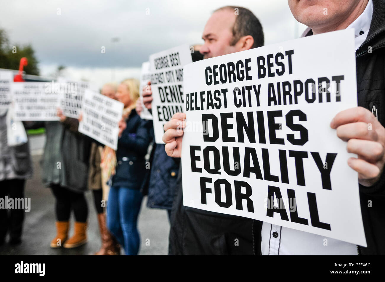 Belfast, Nordirland, Vereinigtes Königreich. 25. Oktober 2013.  Demonstranten halten Plakate sagen "George Best Belfast City Airport bestreitet Gleichheit für alle", nachdem der Flughafen einen Vertrag mit einem einzigen Taxi Lieferanten unterzeichnet, Fahrer, die es Jahren aus dem Geschäft seit zu zwingen. Stockfoto