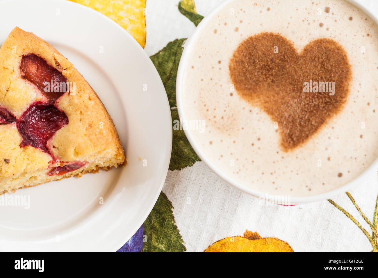 Kuchen mit Pflaumen und eine Tasse Kaffee und Herz. Stockfoto