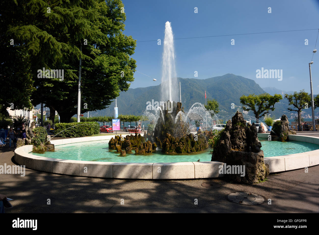 Ein Brunnen und Szenen von der Promenade des Lago di Lugano am Wasser Stockfoto