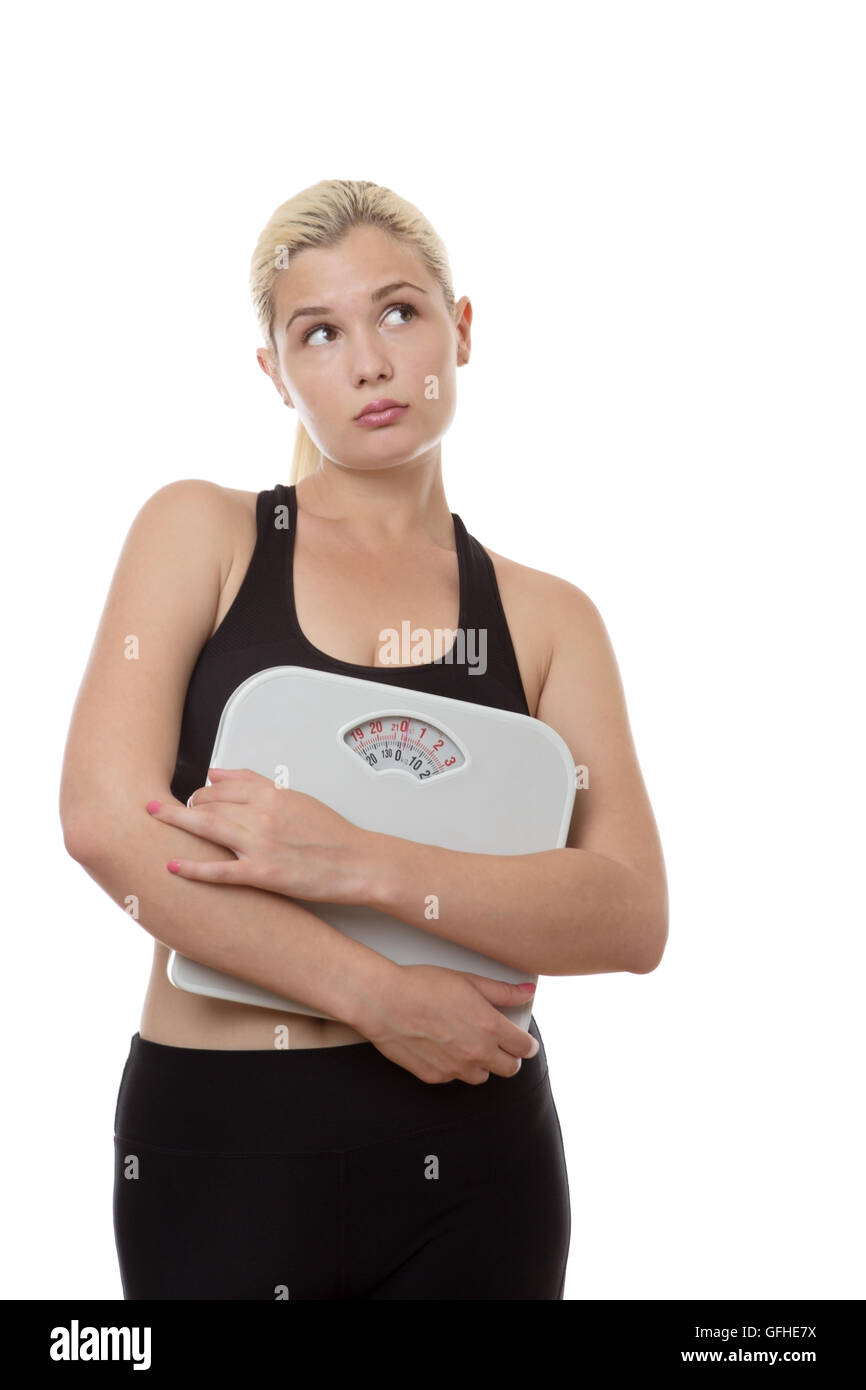 Fitness-Frau mit Skalen auf der Suche aus auf die Seite nicht sicher über ihre Ernährung Stockfoto