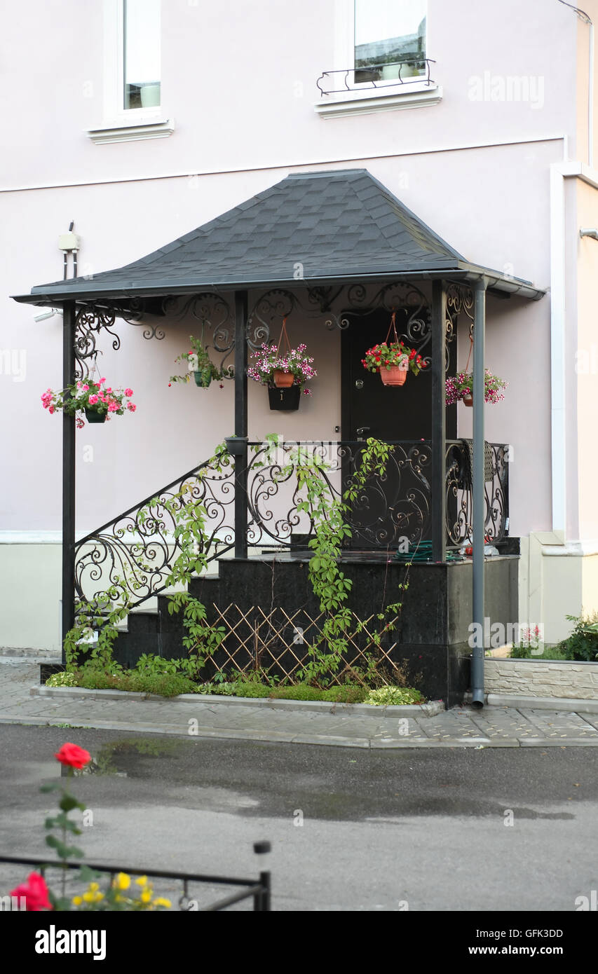 Komfort-Haus. Schöner Eingang mit kleiner Treppe und Blumentöpfe Stockfoto