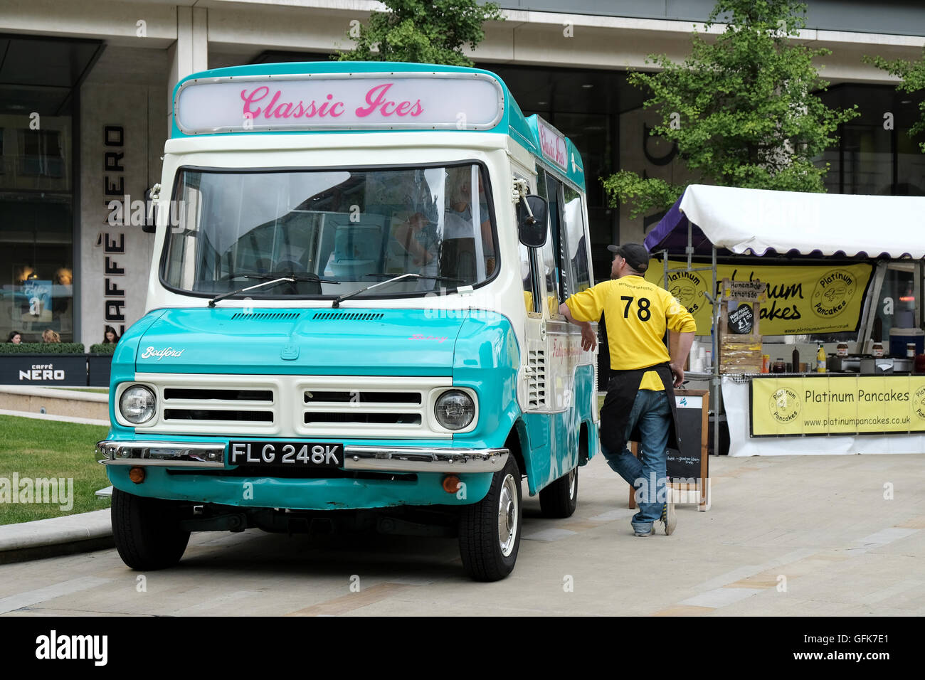 Ein männlicher Kunde wartet auf ein Eis von einem Stillstand, komplett restauriert, traditionelle, Bedford 1972 CF ice cream van Stockfoto