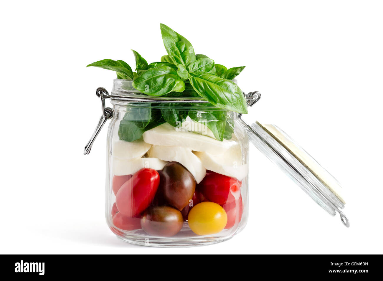 Hofeigene Stil geschichteten Caprese-Salat in ein Einmachglas geöffnetem Deckel vor dem Hinzufügen von dressing Stockfoto