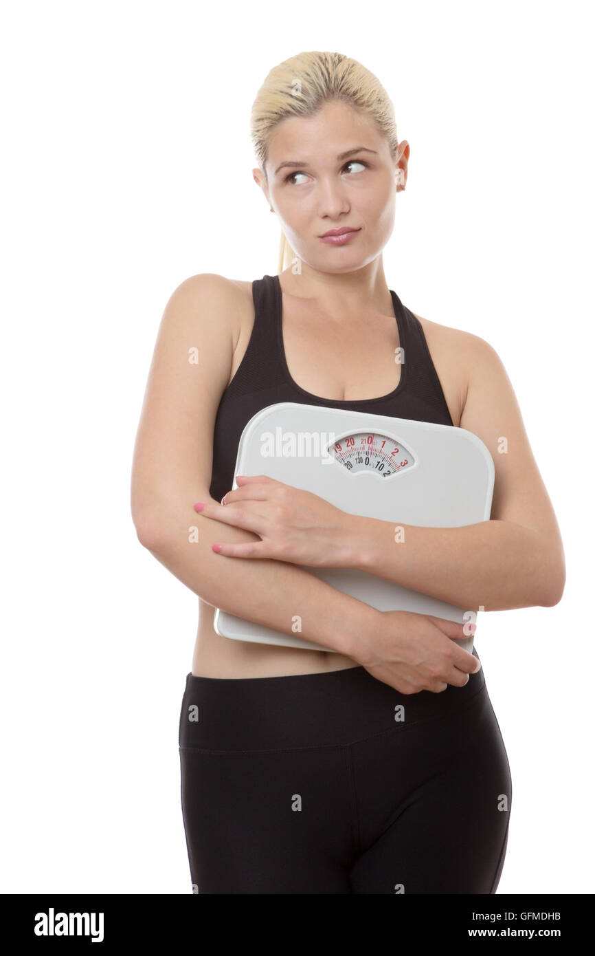 Fitness-Frau mit Skalen auf der Suche aus auf die Seite nicht sicher über ihre Ernährung Stockfoto