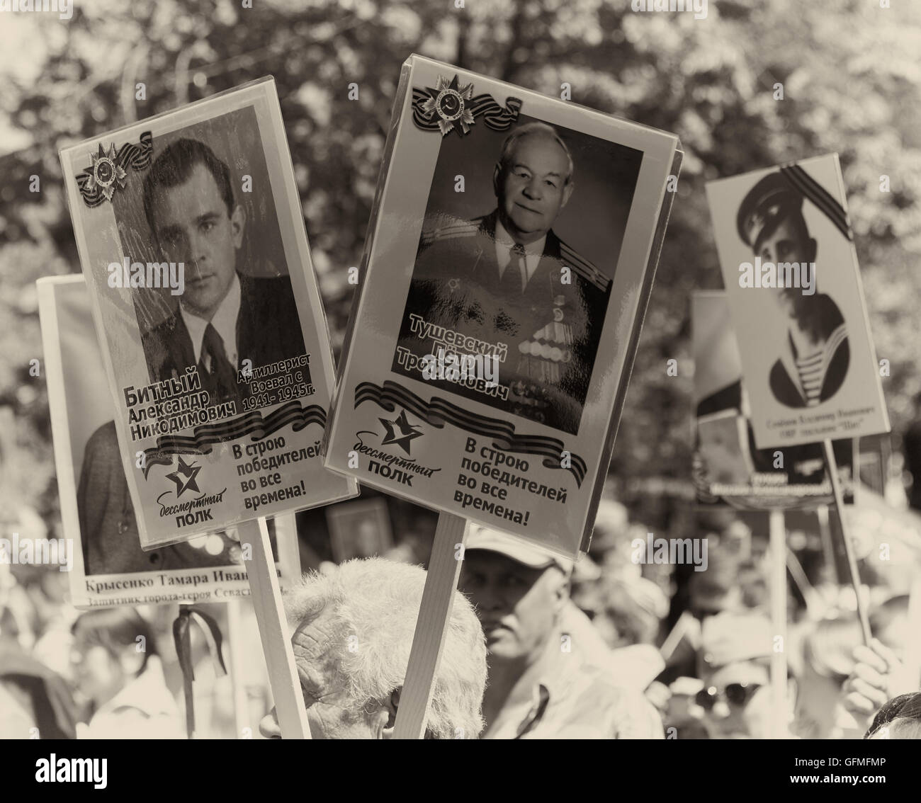 Sepia Bild von Demonstranten mit Fotografien von verwandten Soldaten im 9. Mai Tag des Sieges Parade 2016 Sewastopol Krim Stockfoto
