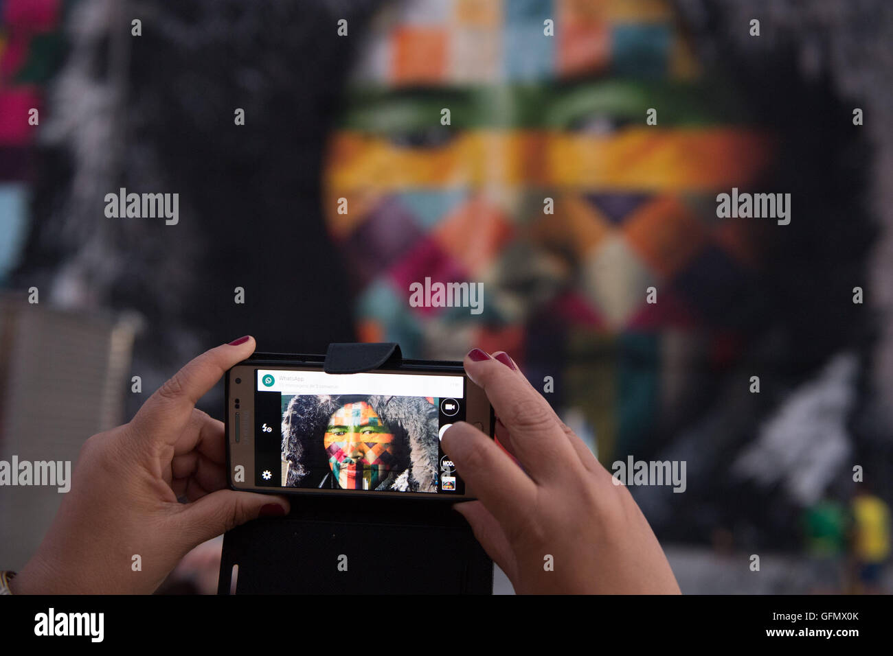 Eine Frau nimmt ein Bild von "Etnias", eine große Graffiti-Wand von brasilianischen Graffiti-Künstler erstellten Eduardo Kobra vor Rio 2016 Olympischen Spiele bei Porto Maravilha in Rio De Janeiro, Brasilien, 31, Juli 2016. Olympische Spiele 2016 in Rio statt von 05 bis 21 August. Foto: Sebastian Kahnert/dpa Stockfoto