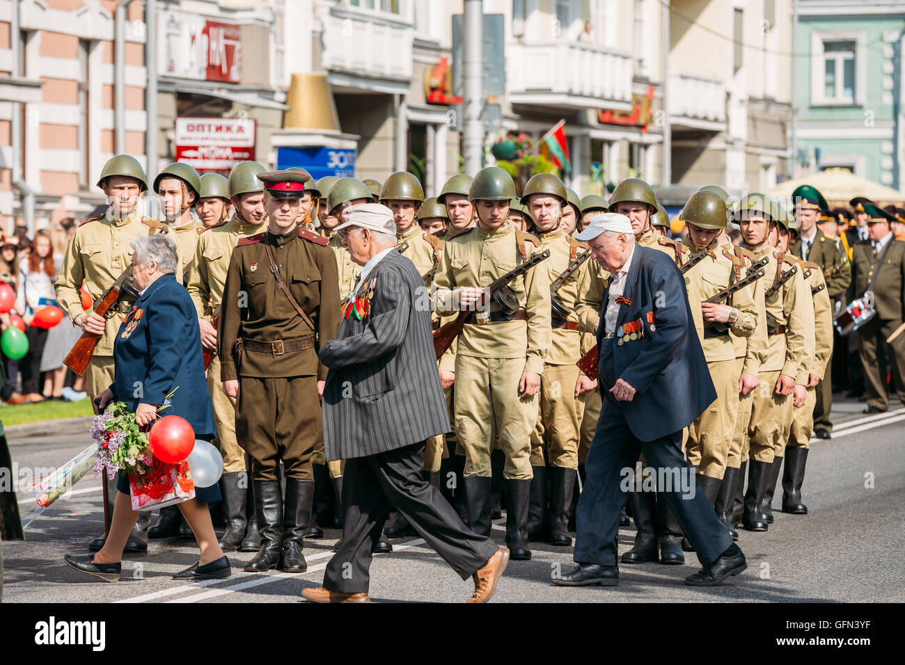 Ältere Menschen geehrt WW2 Veterans Pass in der Nähe das Line-Up von bewaffneten Soldaten In sowjetische WWII Uniform, Offizier im Vordergrund. Re-enactment P Stockfoto