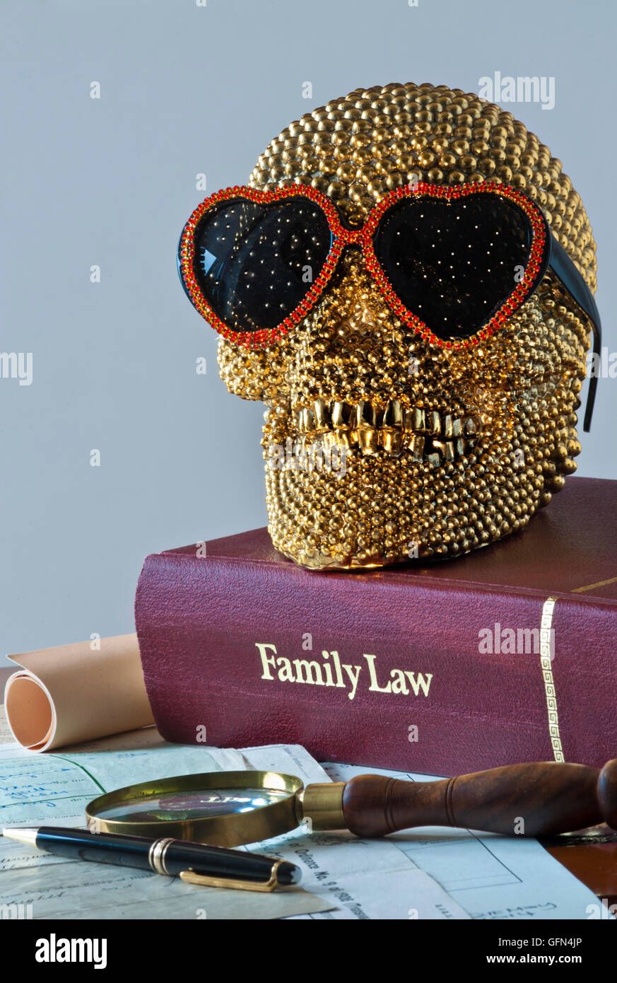 Konzept des Lächelns gold Schädel trägt Herz geformt Sonnenbrille auf Familienrecht Buch mit verschiedenen offiziellen Familie Rechtsdokumente Stockfoto